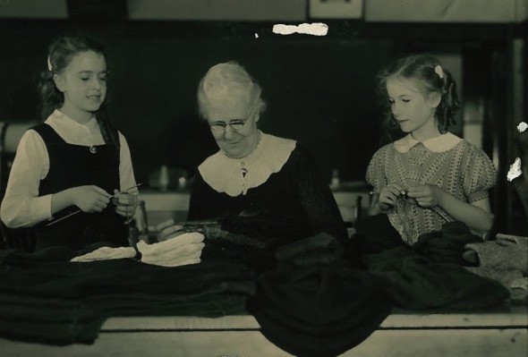 Birch Cliff Principal Ellen Reece knitting with two students.