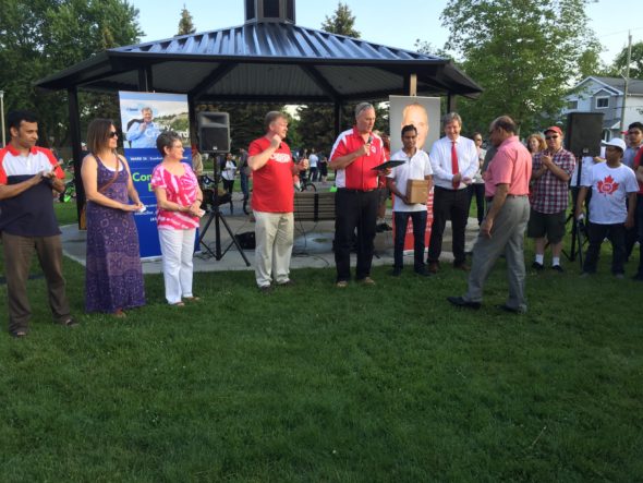 Bill Blair presenting community leaders with pins.